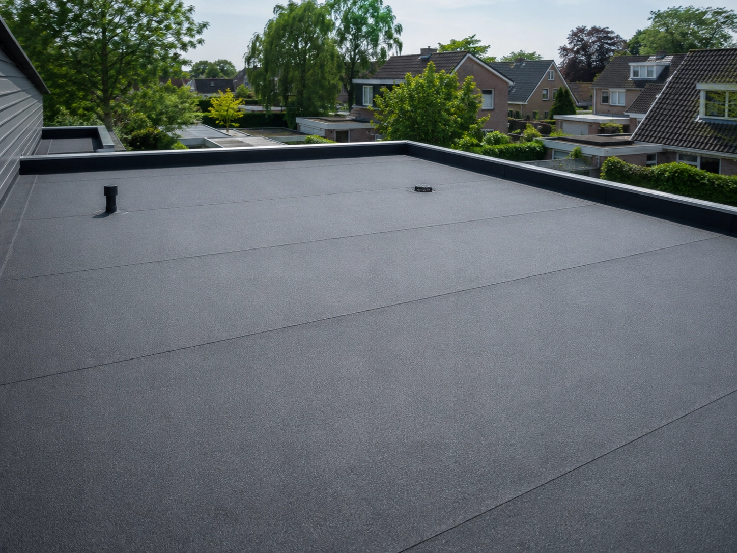 Groot plat dak met afgewerkte bitumen dakbanen en afvoeren